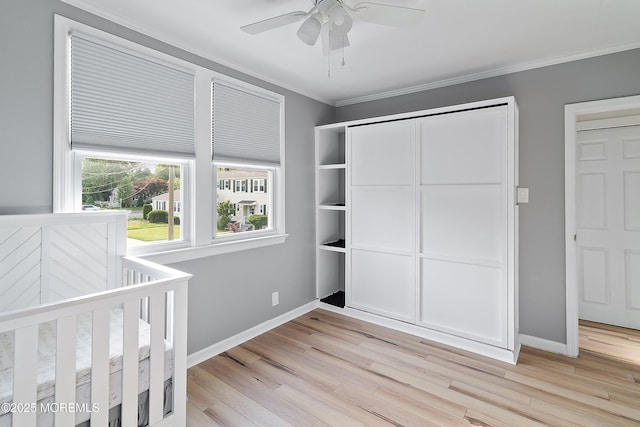 unfurnished bedroom with crown molding, light wood-style flooring, baseboards, and ceiling fan