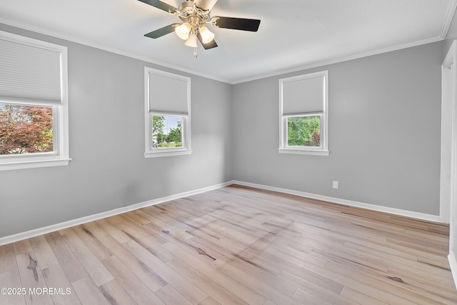empty room featuring plenty of natural light, light wood-style flooring, baseboards, ornamental molding, and ceiling fan