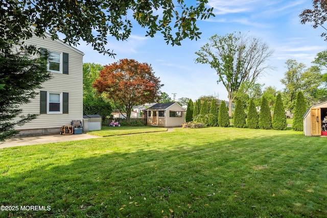 view of grassy yard with an outdoor structure and a patio