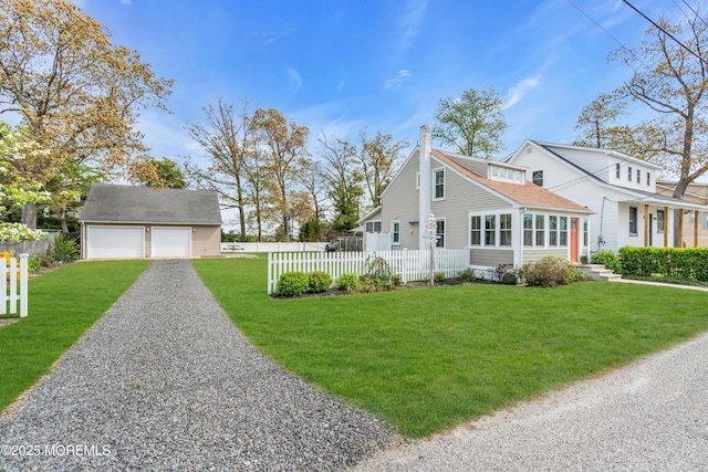 view of property exterior featuring fence, a detached garage, an outdoor structure, a yard, and gravel driveway
