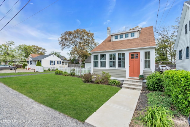 bungalow featuring a front lawn, fence, a chimney, a shingled roof, and entry steps
