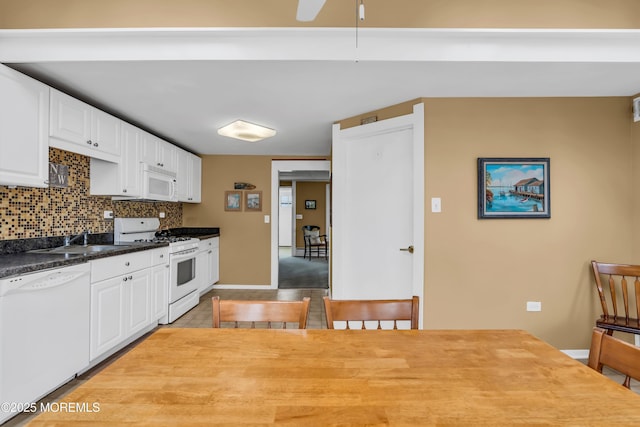 kitchen featuring a sink, tasteful backsplash, white appliances, and white cabinets