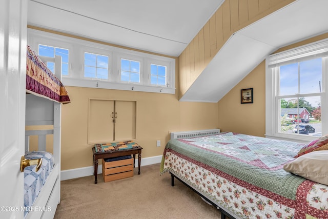 carpeted bedroom featuring baseboards and lofted ceiling