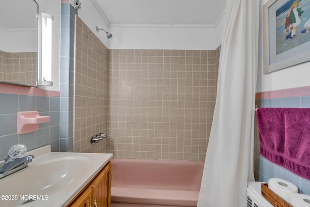 bathroom featuring crown molding, shower / bath combo with shower curtain, tile walls, and vanity