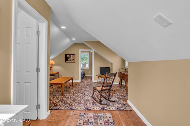 living area with recessed lighting, baseboards, wood finished floors, and vaulted ceiling