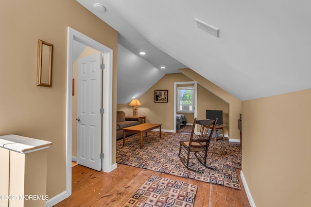 sitting room with baseboards, wood finished floors, and lofted ceiling
