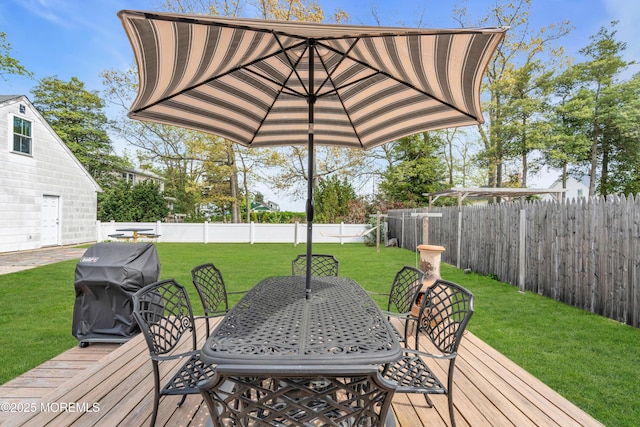 wooden terrace featuring a fenced backyard, outdoor dining space, a yard, and grilling area