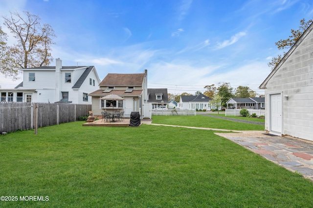 view of yard with a residential view, a wooden deck, and a fenced backyard