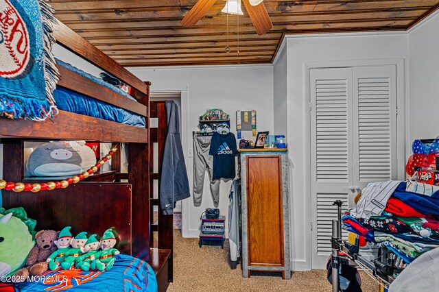 bedroom with carpet flooring, a closet, wooden ceiling, and a ceiling fan