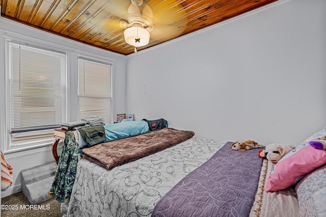 bedroom with wood ceiling, ceiling fan, and carpet floors
