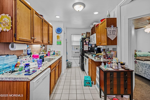 kitchen featuring light tile patterned floors, brown cabinetry, tasteful backsplash, and white appliances