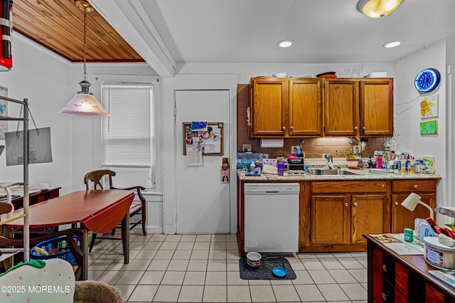 kitchen featuring light countertops, brown cabinets, a sink, and white dishwasher