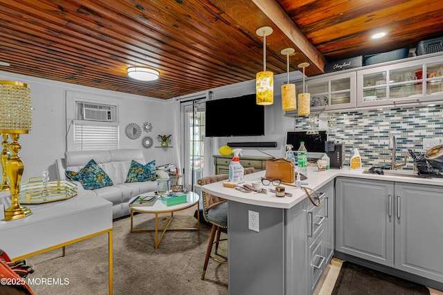kitchen featuring a peninsula, wood ceiling, glass insert cabinets, gray cabinets, and light countertops