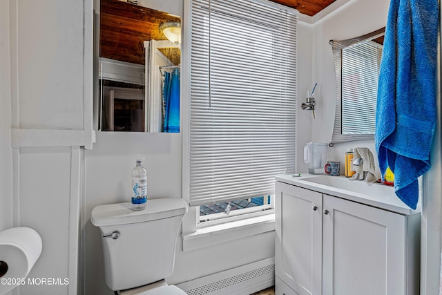 bathroom with toilet, vanity, and a baseboard heating unit
