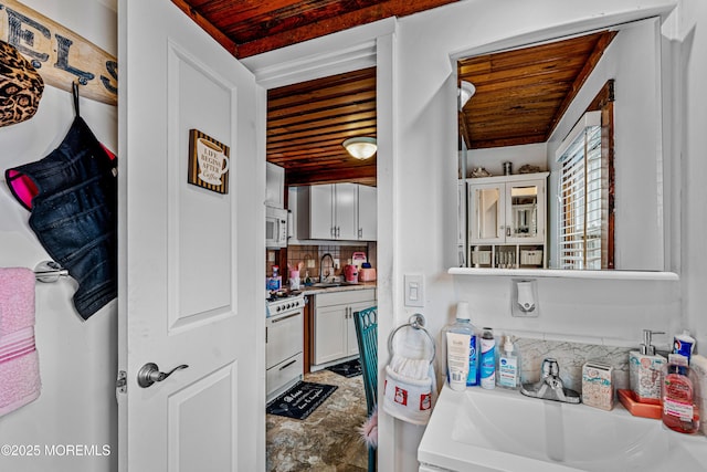 bathroom featuring backsplash, wood ceiling, and a sink