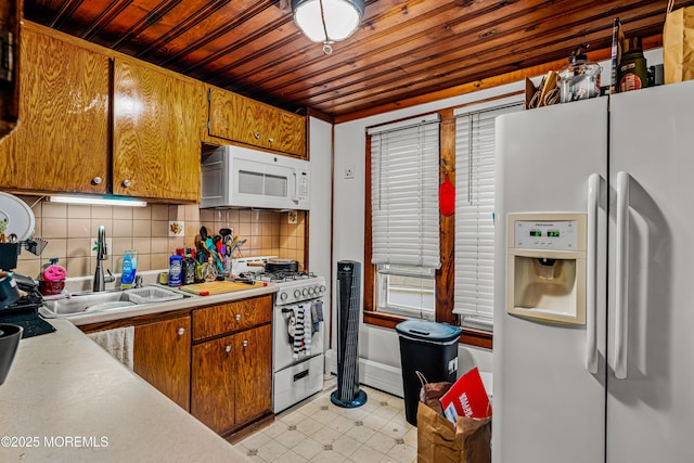 kitchen featuring white appliances, wood ceiling, a sink, decorative backsplash, and light countertops