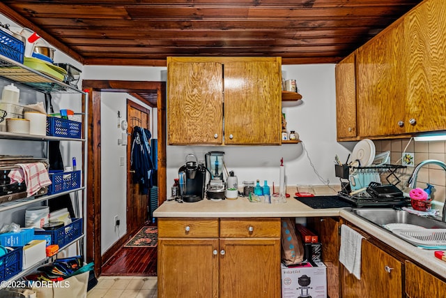 kitchen with a sink, light countertops, open shelves, and wooden ceiling