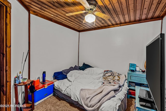 bedroom featuring wooden ceiling, ornamental molding, carpet floors, and a ceiling fan