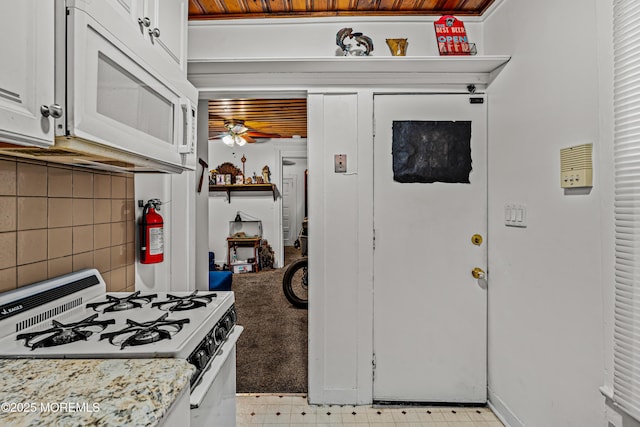 kitchen featuring a ceiling fan, light floors, white appliances, white cabinetry, and backsplash