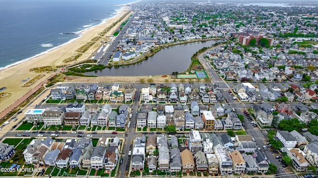 drone / aerial view with a water view, a residential view, and a view of the beach