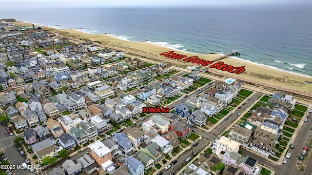 drone / aerial view featuring a water view, a residential view, and a view of the beach