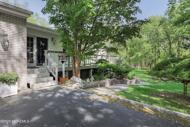 exterior space featuring a yard, a patio, and brick siding