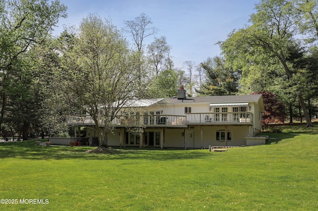 rear view of property featuring a yard, a deck, and a chimney