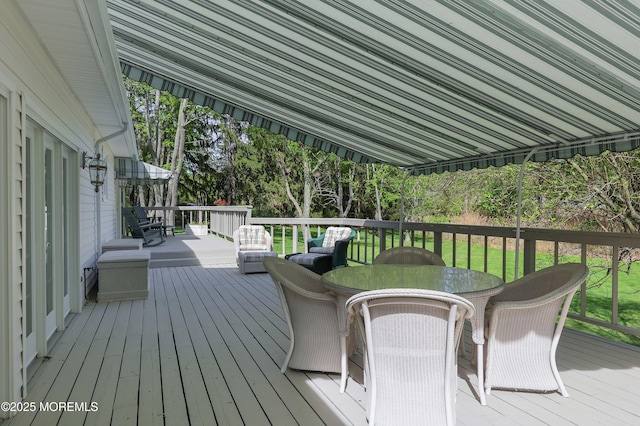 wooden terrace featuring a yard and outdoor dining space
