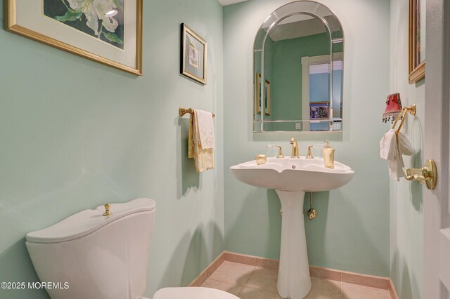 bathroom with toilet, baseboards, and tile patterned floors