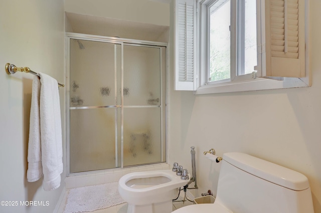 full bath with a stall shower, toilet, and a bidet