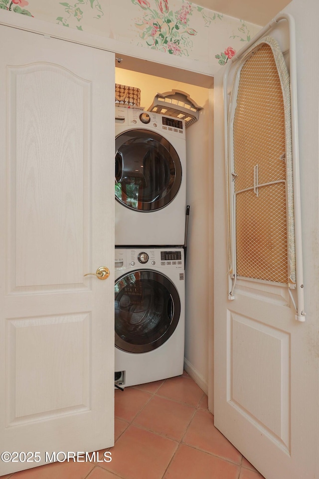 laundry area with laundry area, stacked washing maching and dryer, and light tile patterned floors