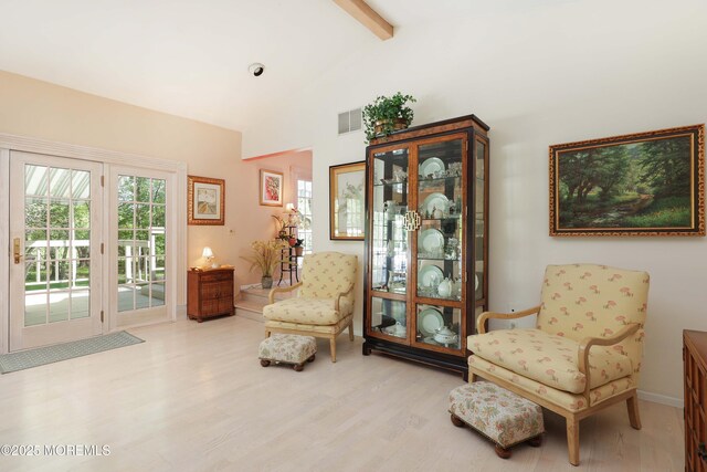 sitting room featuring vaulted ceiling with beams, baseboards, visible vents, and wood finished floors