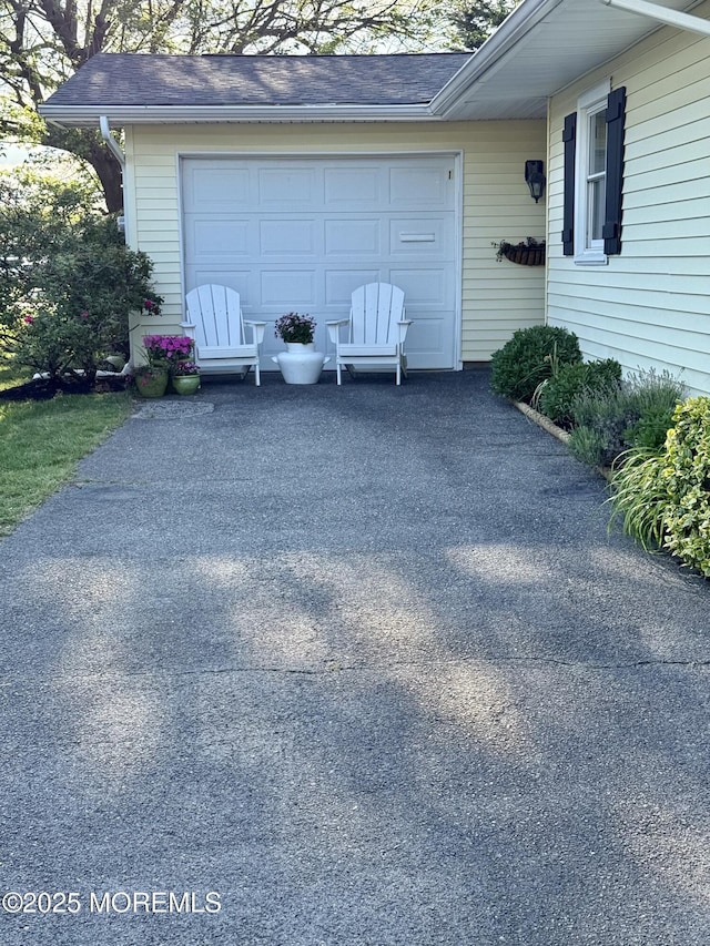 garage featuring asphalt driveway