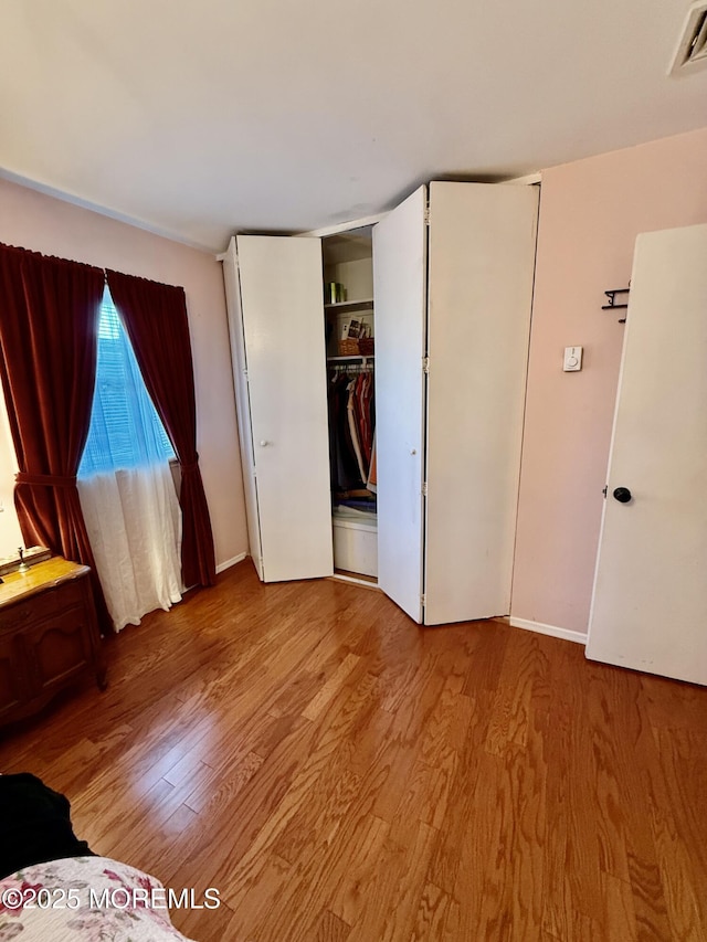 unfurnished bedroom with light wood-type flooring and baseboards