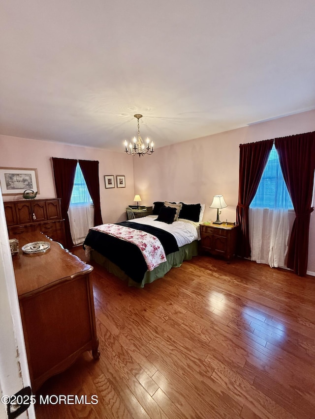 bedroom with wood finished floors and a chandelier