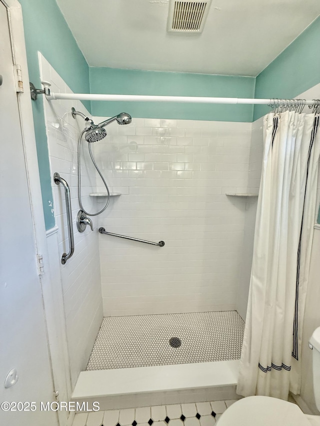 full bath with toilet and a stall shower