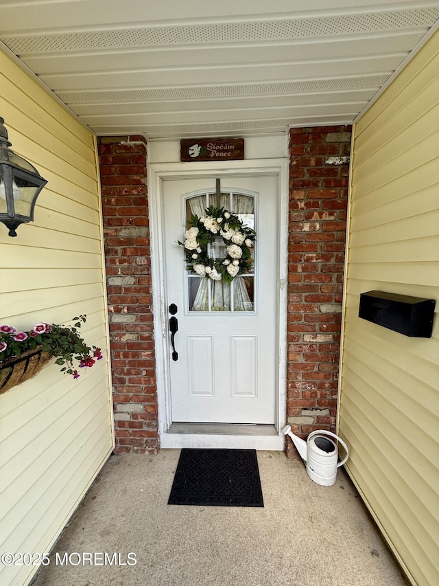 view of exterior entry with brick siding