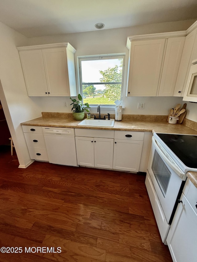 kitchen featuring a sink, white appliances, white cabinets, and dark wood-style floors