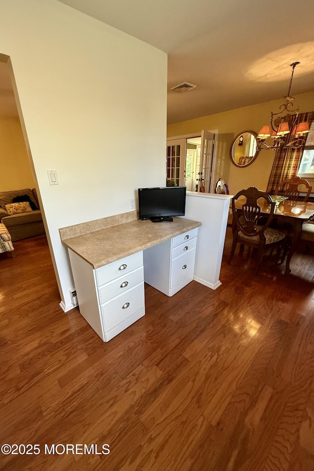 kitchen with dark wood-style floors, light countertops, white cabinets, and a chandelier