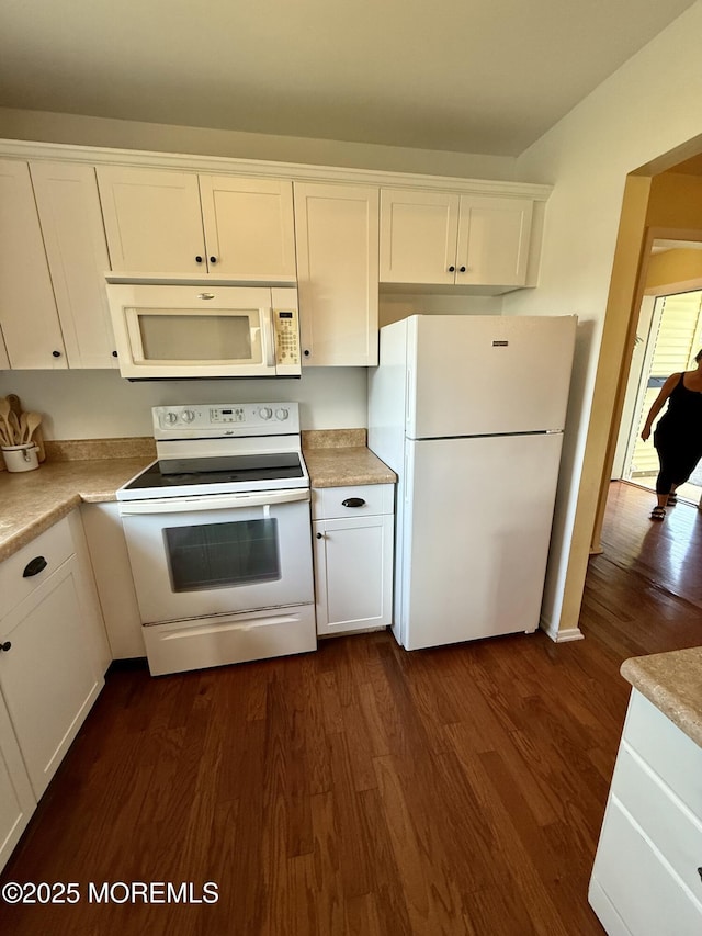 kitchen with white appliances, dark wood-style floors, white cabinetry, and light countertops