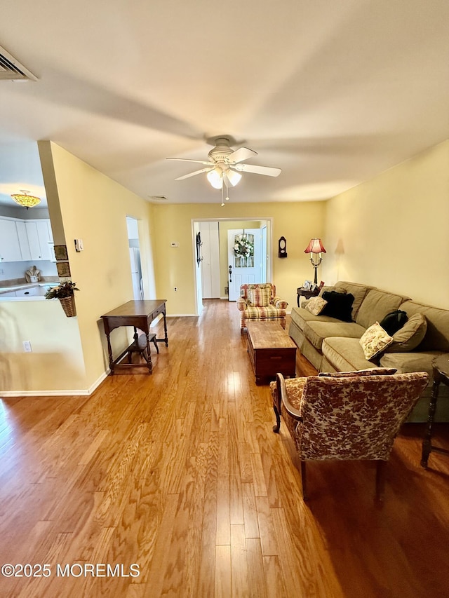 living room featuring light wood-style flooring and ceiling fan