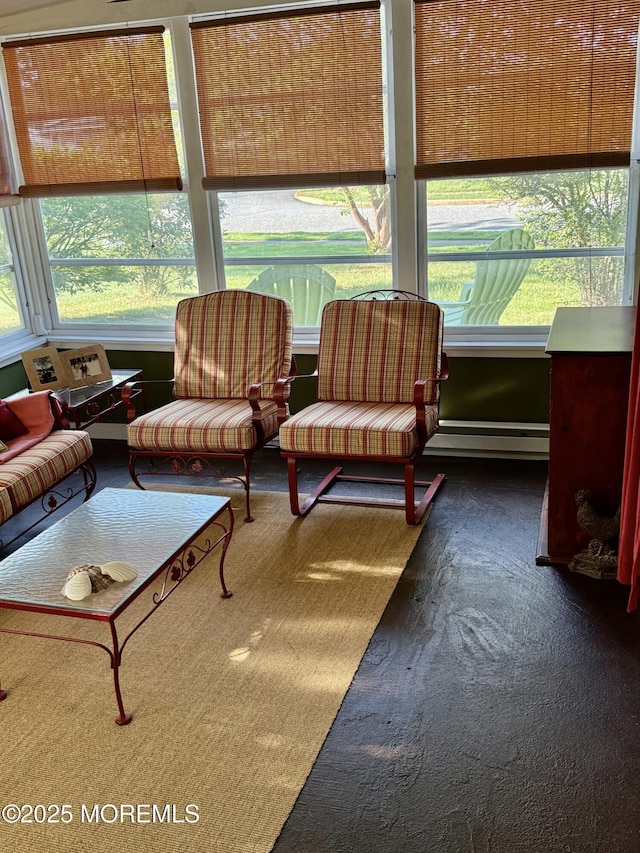 sunroom featuring healthy amount of natural light and a baseboard heating unit