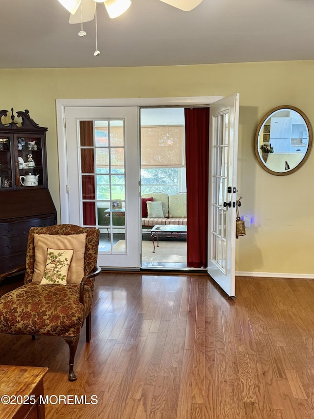 entryway with wood finished floors, a ceiling fan, and baseboards
