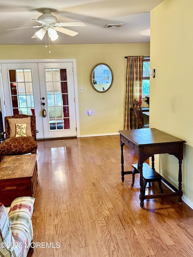 entrance foyer featuring wood finished floors, a ceiling fan, french doors, and plenty of natural light