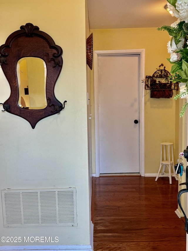 hallway with wood finished floors and baseboards