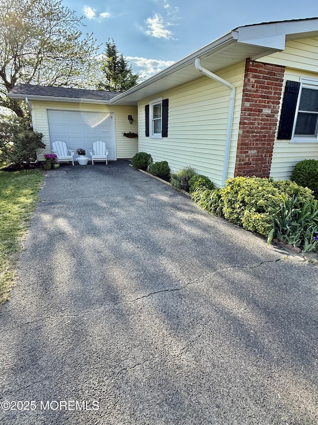 view of property exterior with driveway and a garage