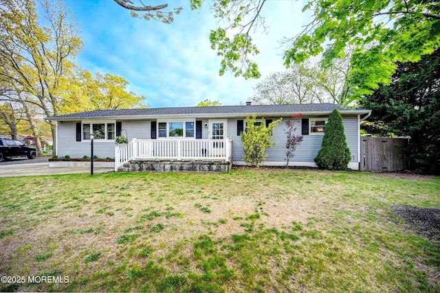 ranch-style house featuring a porch, fence, a chimney, and a front yard