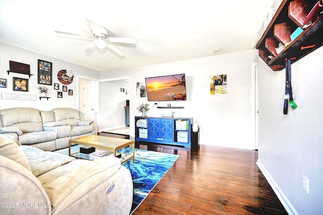 living area featuring a ceiling fan, baseboards, and hardwood / wood-style flooring