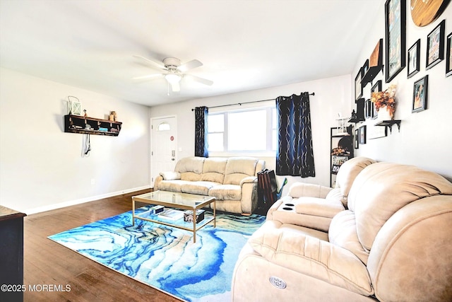 living room with a ceiling fan, baseboards, and wood finished floors