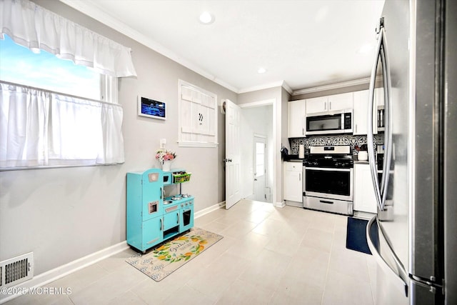 kitchen with visible vents, ornamental molding, white cabinetry, tasteful backsplash, and stainless steel appliances